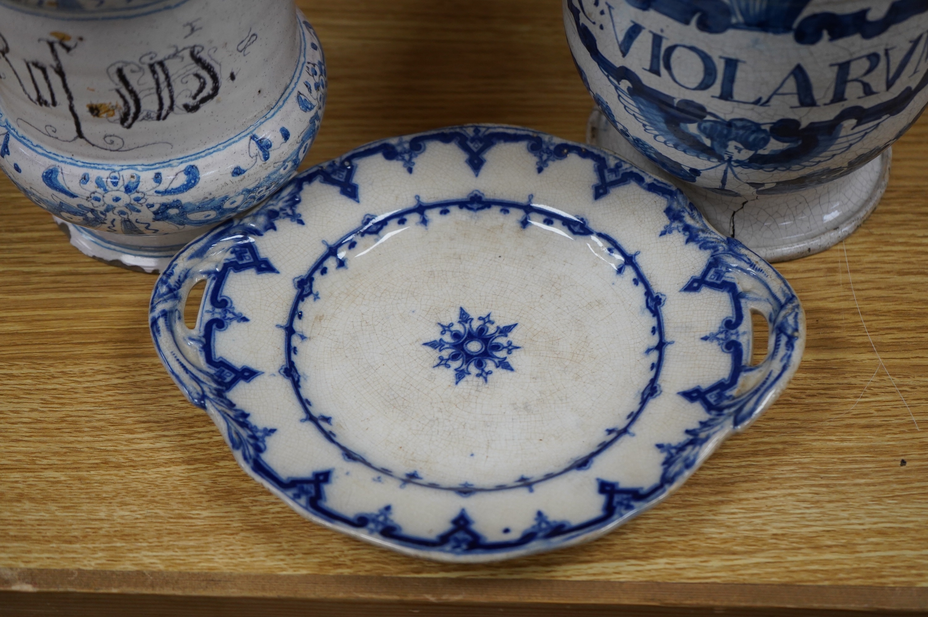 A 17th /18th century blue and white Delft apothecary jar, together with an Italian blue and white pottery drug jar and a blue and white ‘Saxon Star’ two handled dish, tallest 19cm. Condition - poor